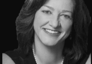 Black-and-white portrait of smiling woman with pearls
